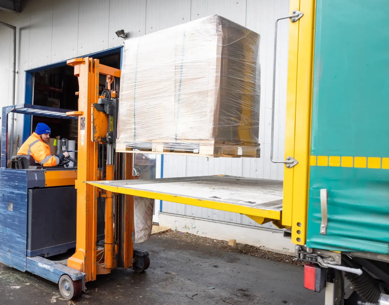Gabelstaplerfahrer lädt Palette auf LKW.
